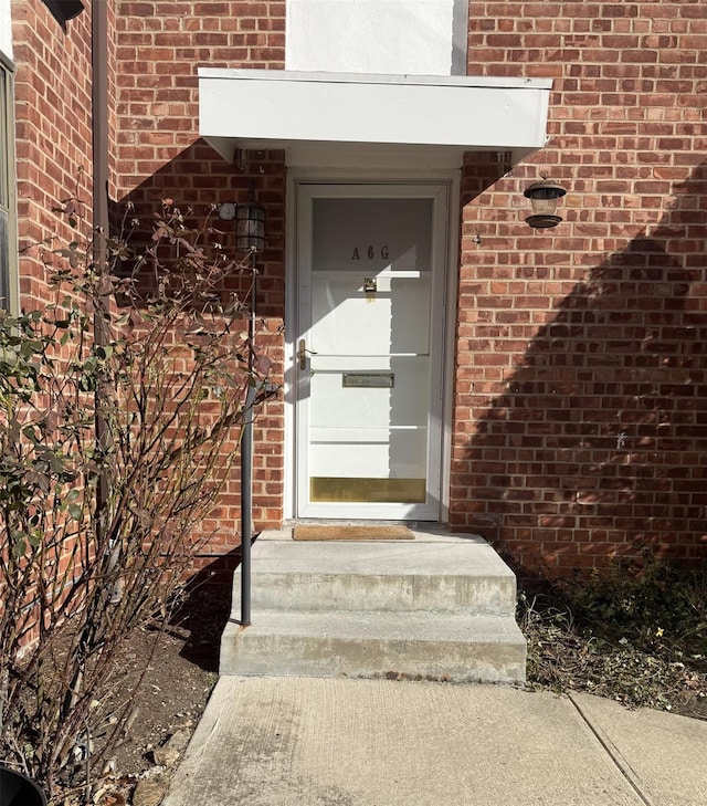 doorway to property featuring brick siding