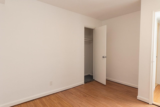 unfurnished bedroom with a closet and light hardwood / wood-style flooring