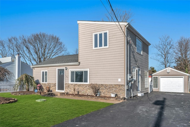 view of property with a front yard, a garage, and an outdoor structure