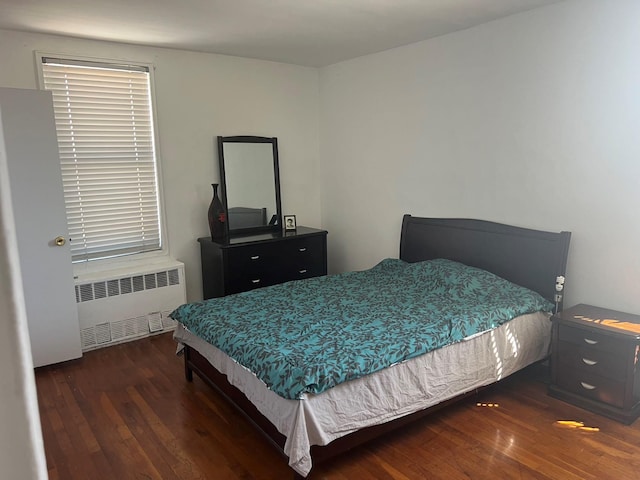 bedroom with radiator and wood finished floors