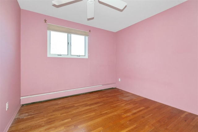 spare room with ceiling fan, baseboard heating, and hardwood / wood-style flooring