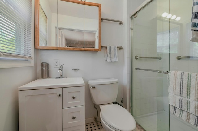 bathroom with vanity, toilet, and a shower with shower door