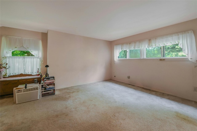 spare room with carpet and an AC wall unit