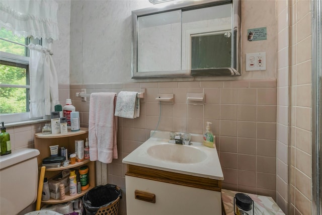 bathroom with vanity, tile walls, and toilet