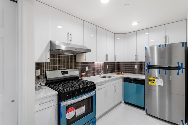 kitchen featuring tasteful backsplash, stainless steel appliances, sink, light tile patterned floors, and white cabinetry