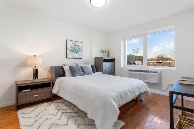 bedroom featuring a wall unit AC and wood-type flooring