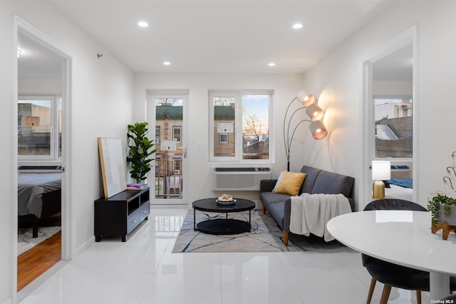 living room with light tile patterned flooring and a wall mounted air conditioner