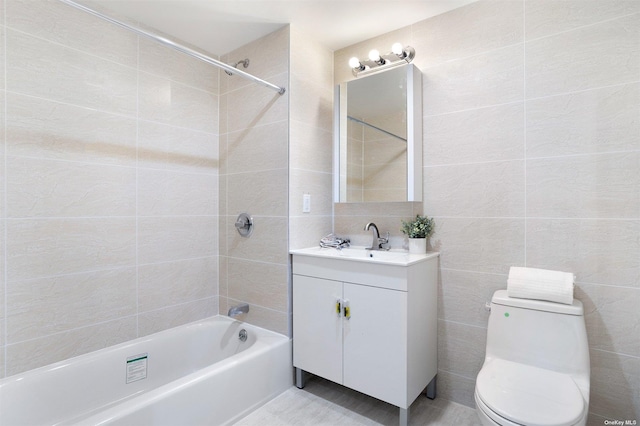 full bathroom with shower / bathing tub combination, vanity, toilet, and tile walls