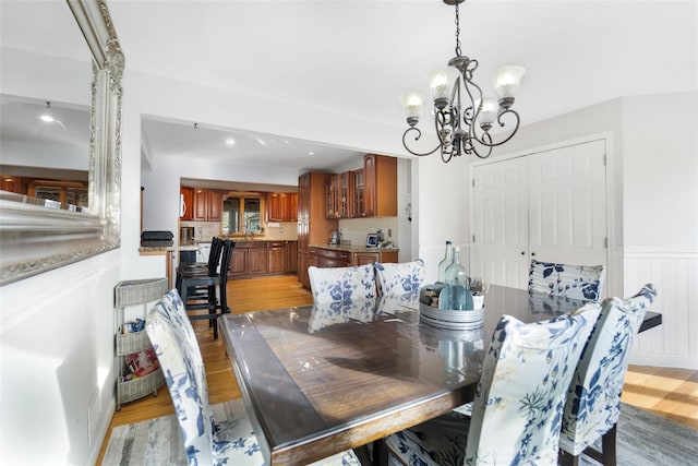 dining area featuring light wood-type flooring and an inviting chandelier