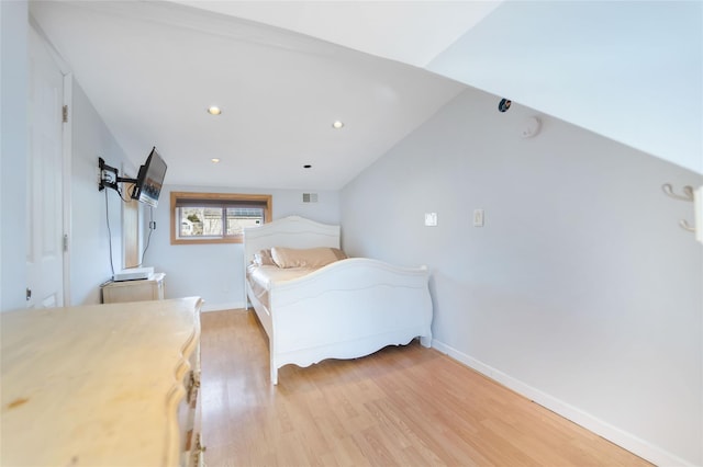 bedroom featuring lofted ceiling and light hardwood / wood-style floors