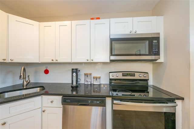 kitchen featuring white cabinets, appliances with stainless steel finishes, tasteful backsplash, and sink