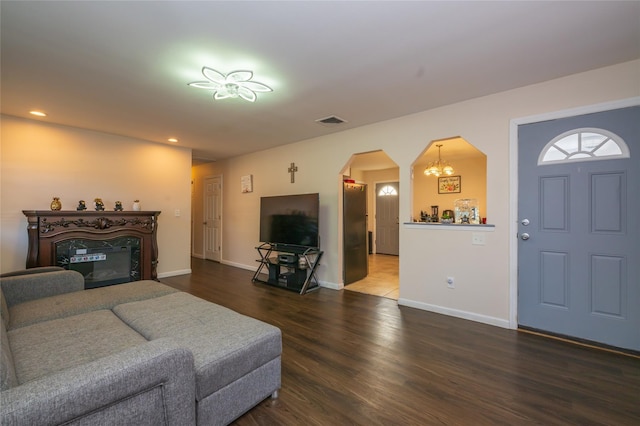 living room featuring dark wood-type flooring and an inviting chandelier