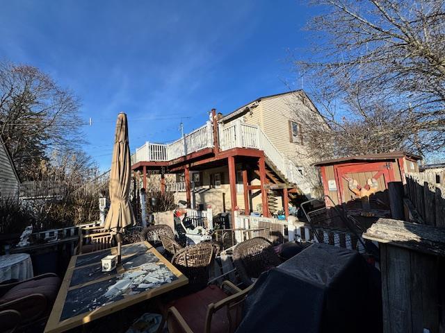 view of side of property with a storage unit and a deck