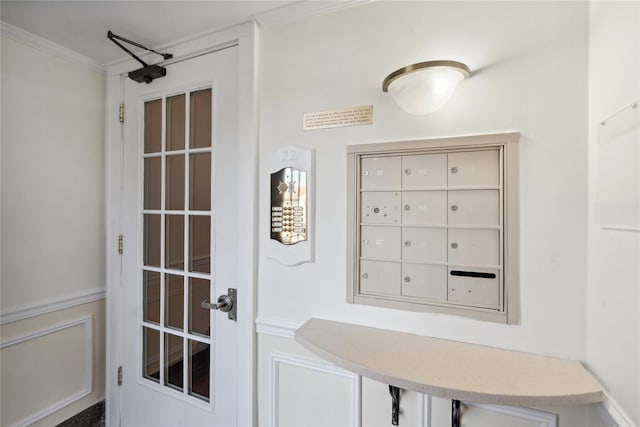 mudroom with crown molding and mail area