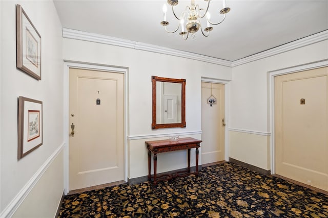 foyer with crown molding, baseboards, and an inviting chandelier