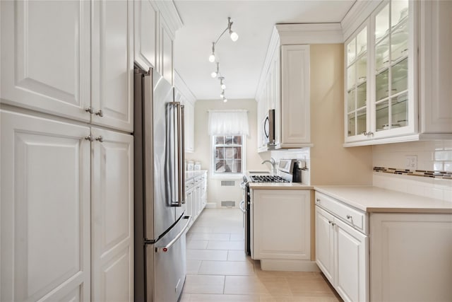 kitchen with glass insert cabinets, appliances with stainless steel finishes, and white cabinets