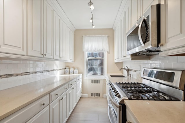 kitchen with white cabinetry, stainless steel appliances, and a sink