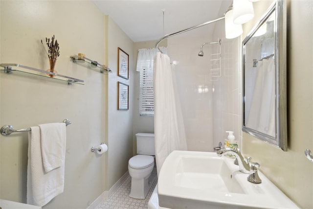 bathroom with a shower with shower curtain, toilet, a sink, tile patterned flooring, and baseboards