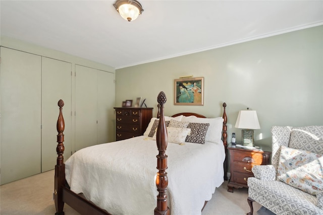 bedroom featuring crown molding, light colored carpet, and multiple closets