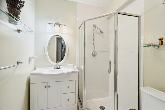 bathroom with toilet, a shower stall, and vanity