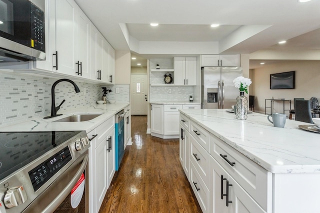 kitchen with sink, white cabinetry, stainless steel appliances, and tasteful backsplash