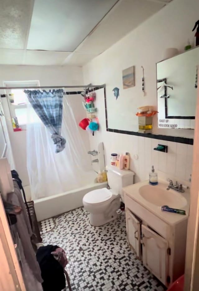 full bathroom with shower / tub combo, vanity, toilet, and tile walls