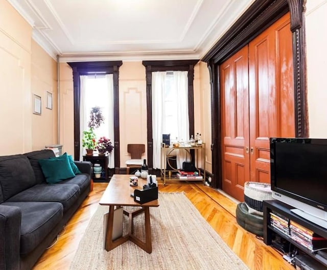 living room with light hardwood / wood-style flooring and crown molding