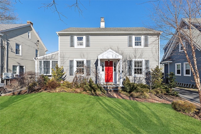 colonial-style house with a front lawn