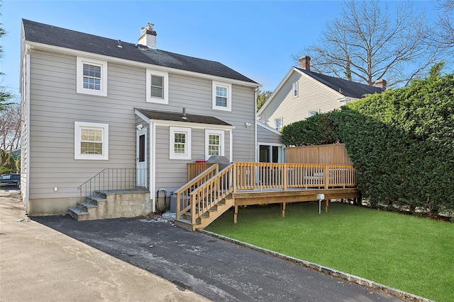 back of property featuring a yard and a deck