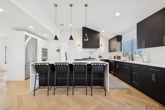 kitchen featuring decorative light fixtures, a center island, and light parquet floors