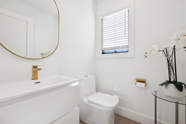 bathroom with toilet, vanity, and tile patterned floors