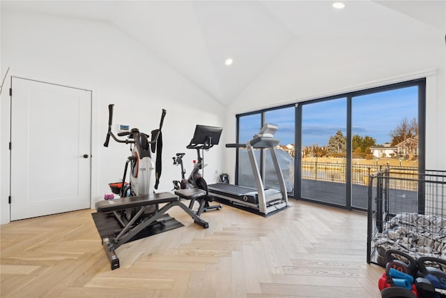 exercise room with parquet flooring and high vaulted ceiling