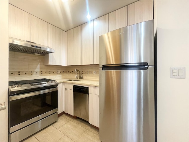 kitchen featuring sink, light brown cabinets, light tile patterned flooring, tasteful backsplash, and appliances with stainless steel finishes