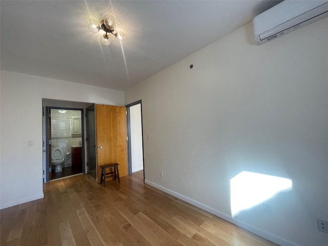 empty room with wood-type flooring and an AC wall unit