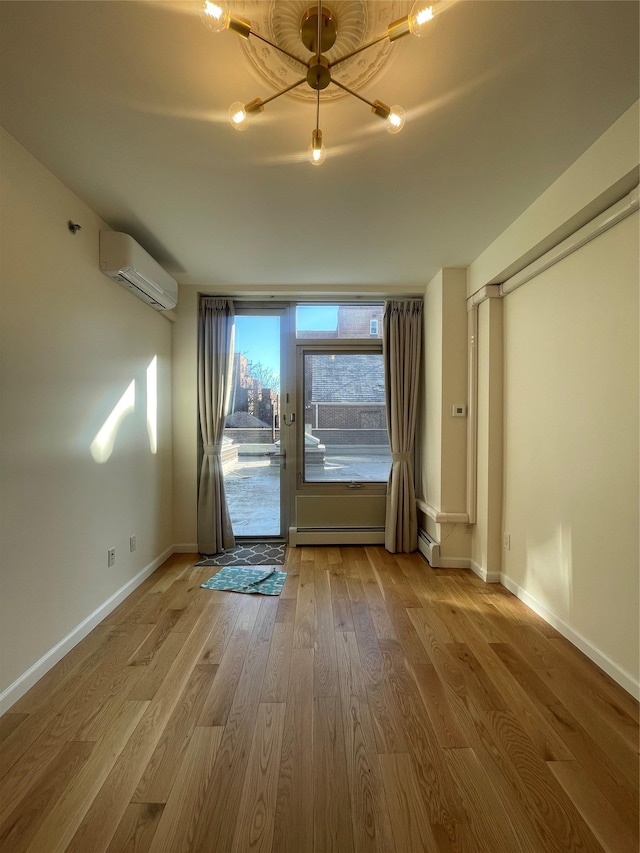 interior space with baseboard heating, a wall mounted air conditioner, and hardwood / wood-style floors