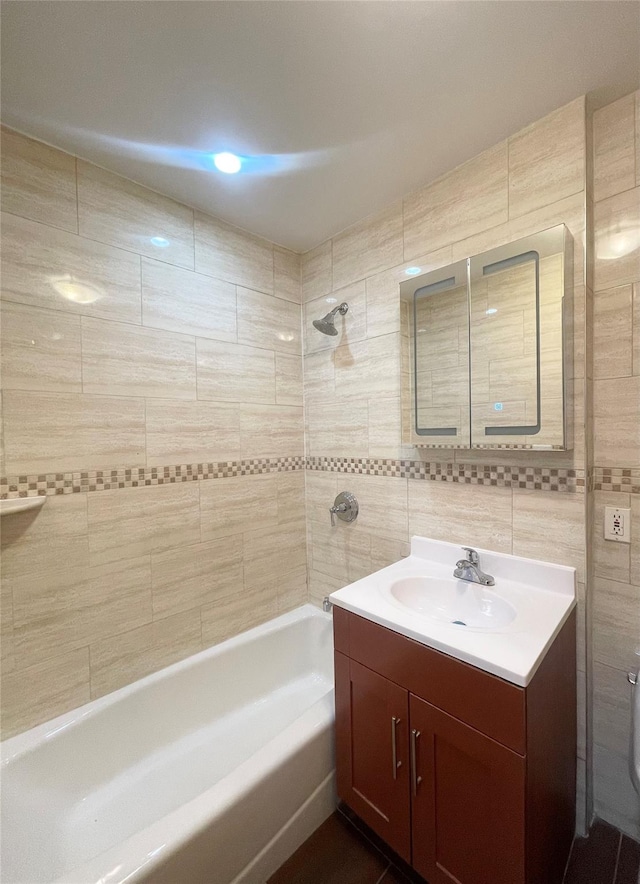 bathroom featuring vanity, tile walls, and bathtub / shower combination