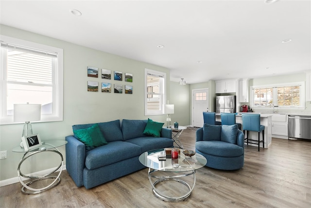 living room with sink and light hardwood / wood-style floors