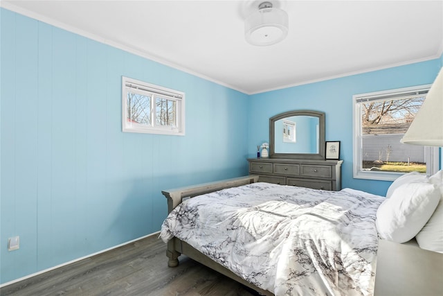 bedroom featuring dark hardwood / wood-style floors, ornamental molding, and multiple windows