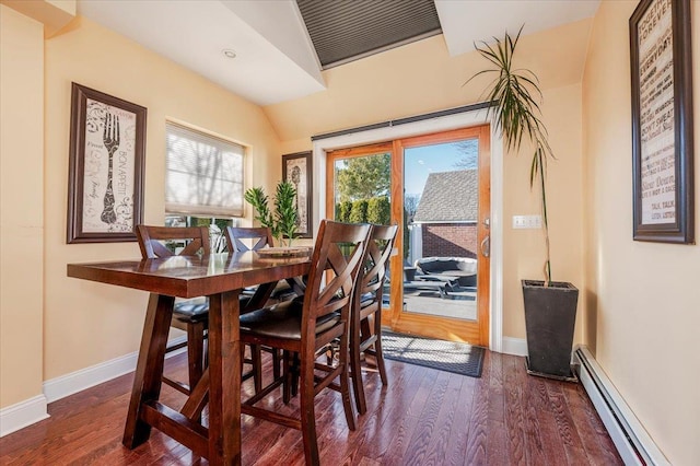 dining space featuring a baseboard radiator, lofted ceiling, and dark wood-type flooring