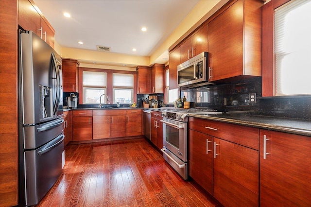 kitchen with tasteful backsplash, sink, dark hardwood / wood-style flooring, and stainless steel appliances