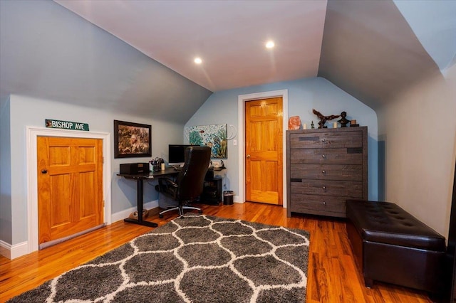 home office with vaulted ceiling and hardwood / wood-style floors