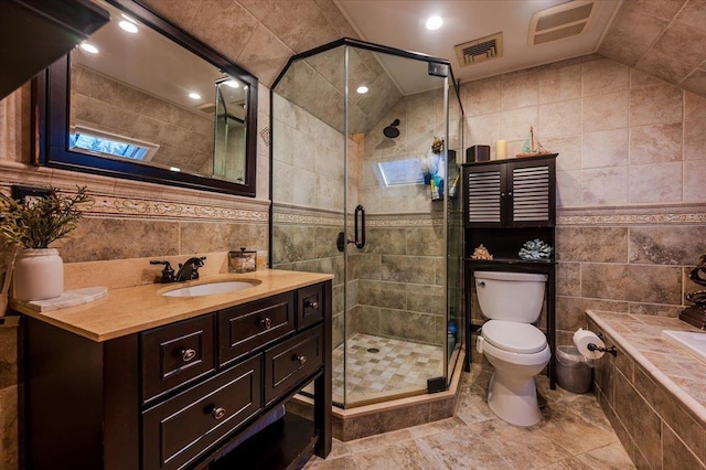 bathroom featuring lofted ceiling, a shower with shower door, tile walls, and vanity