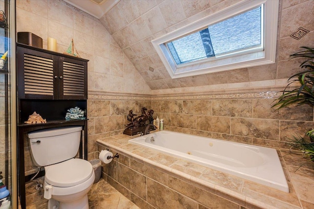 bathroom featuring toilet, vaulted ceiling with skylight, tile walls, and a relaxing tiled tub