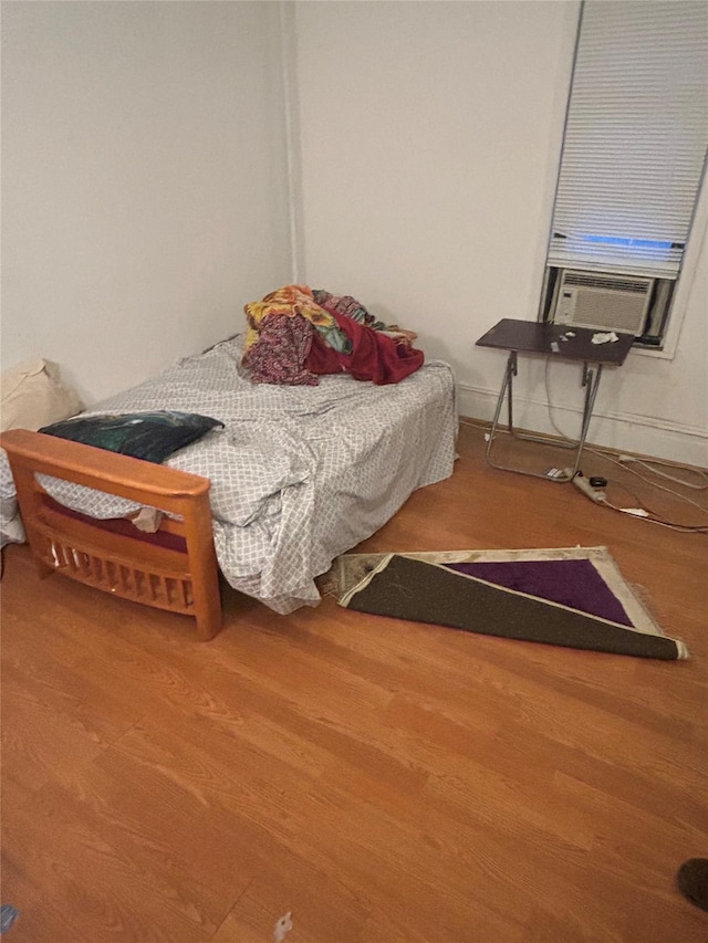 bedroom featuring hardwood / wood-style floors and cooling unit