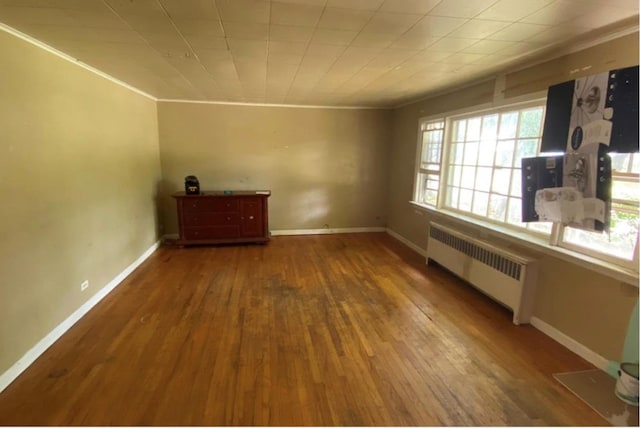 spare room with radiator and hardwood / wood-style floors