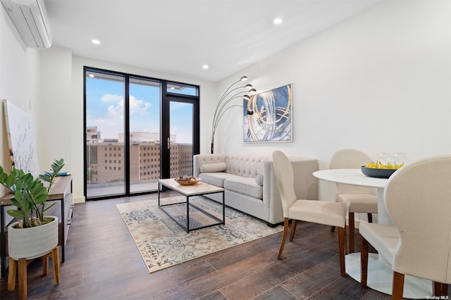 living room with a wall unit AC, expansive windows, and dark wood-type flooring