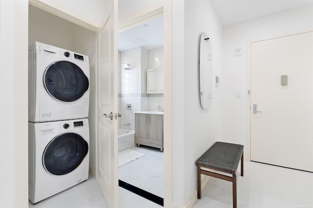 clothes washing area featuring stacked washer / dryer