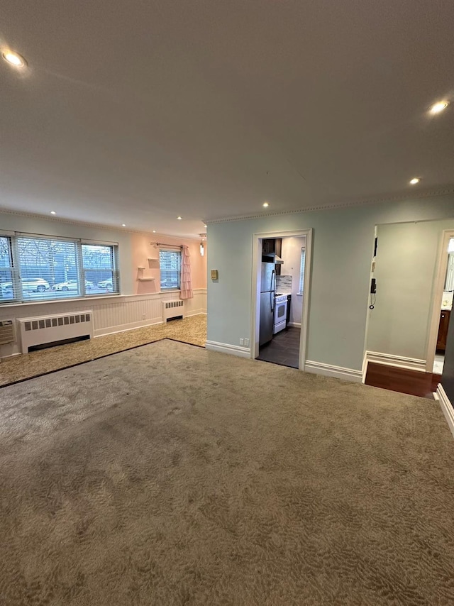 unfurnished living room with dark colored carpet and radiator