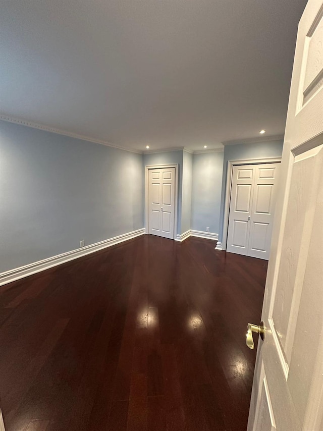 interior space with dark hardwood / wood-style flooring and ornamental molding