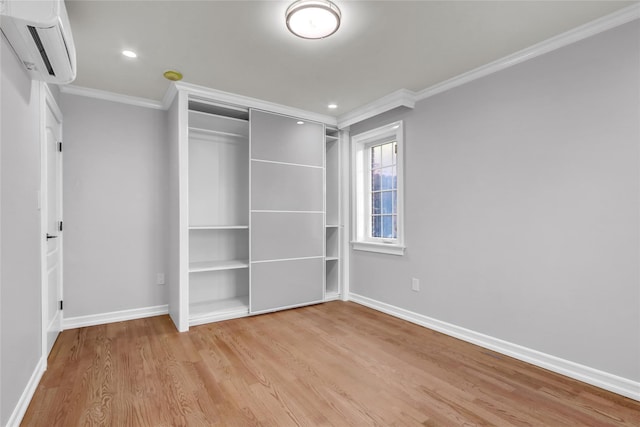 unfurnished bedroom featuring light wood-type flooring, ornamental molding, and a wall mounted AC